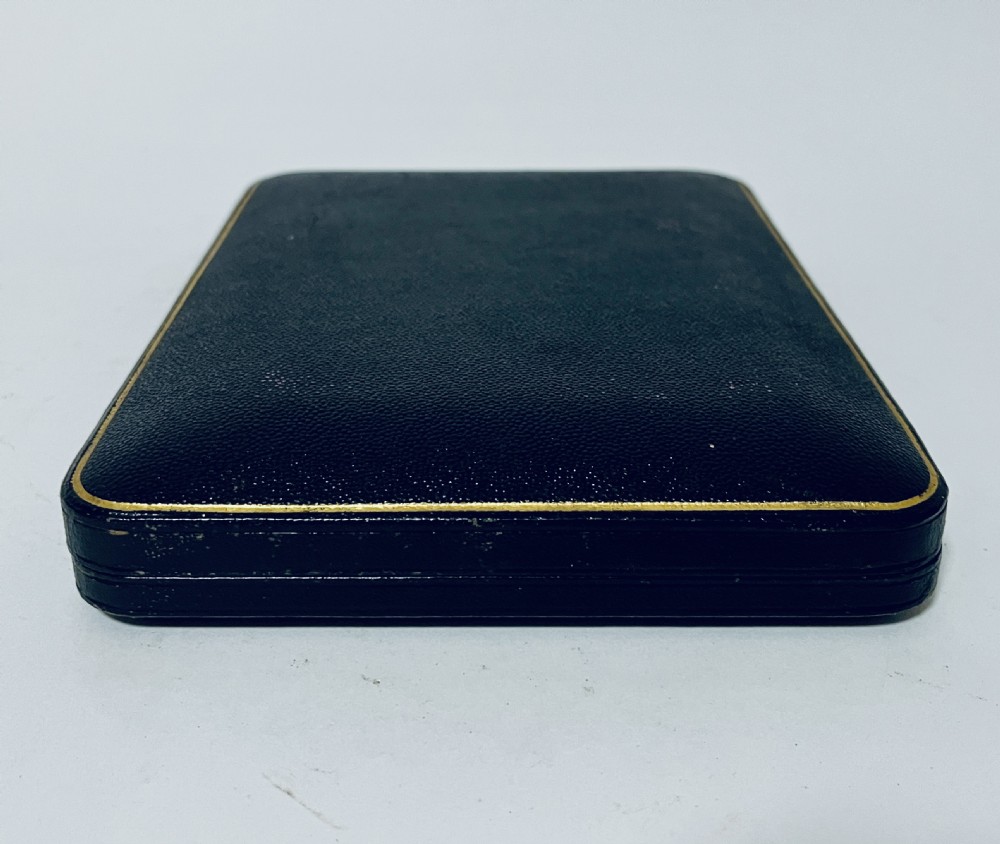 A cased set of six silver teaspoons and matching sugar tongs arranged in a blue velvet lined presentation box with cream satin lid. View IV