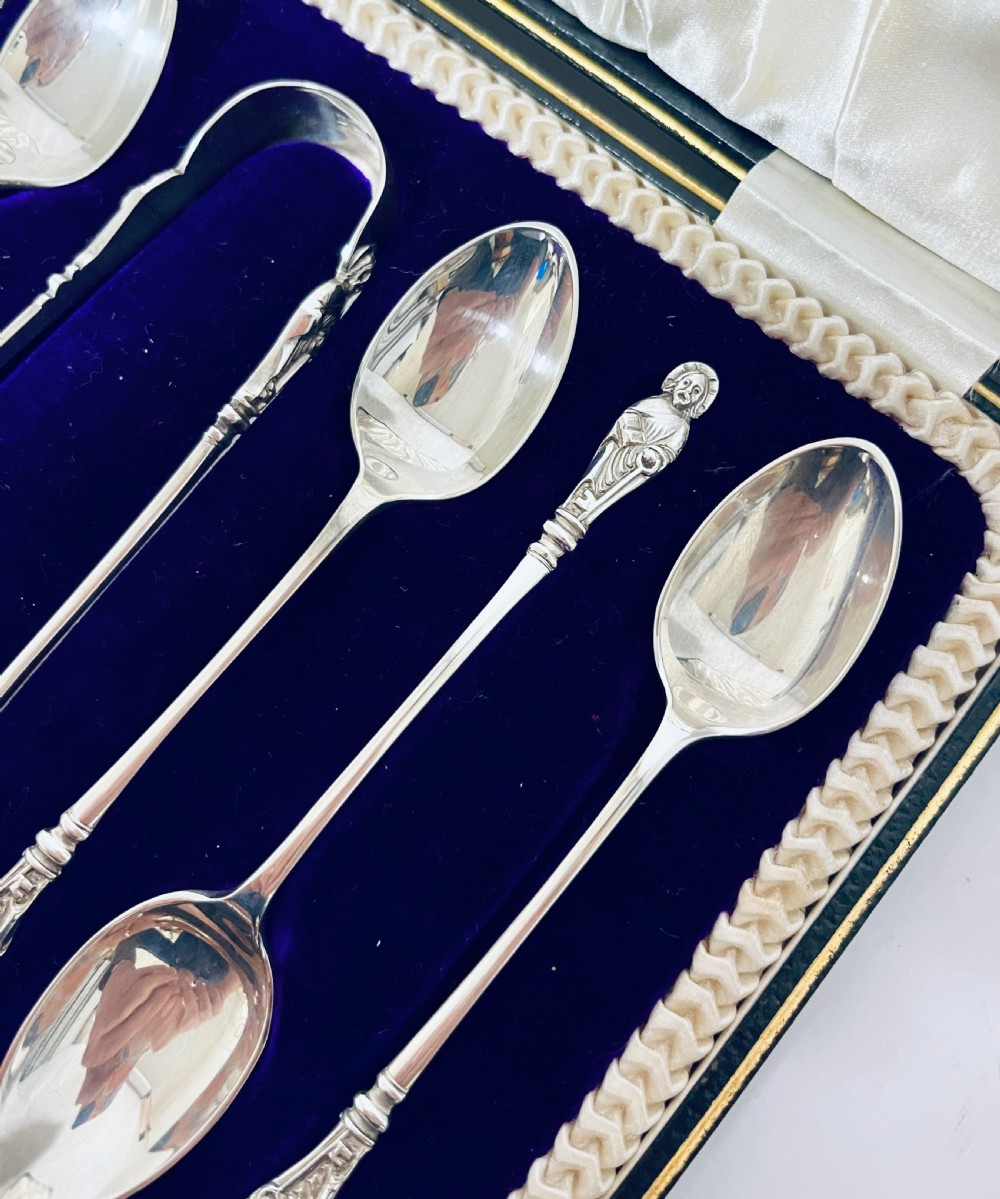 A cased set of six silver teaspoons and matching sugar tongs arranged in a blue velvet lined presentation box with cream satin lid. View VI