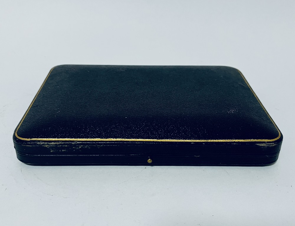 A cased set of six silver teaspoons and matching sugar tongs arranged in a blue velvet lined presentation box with cream satin lid. View VII