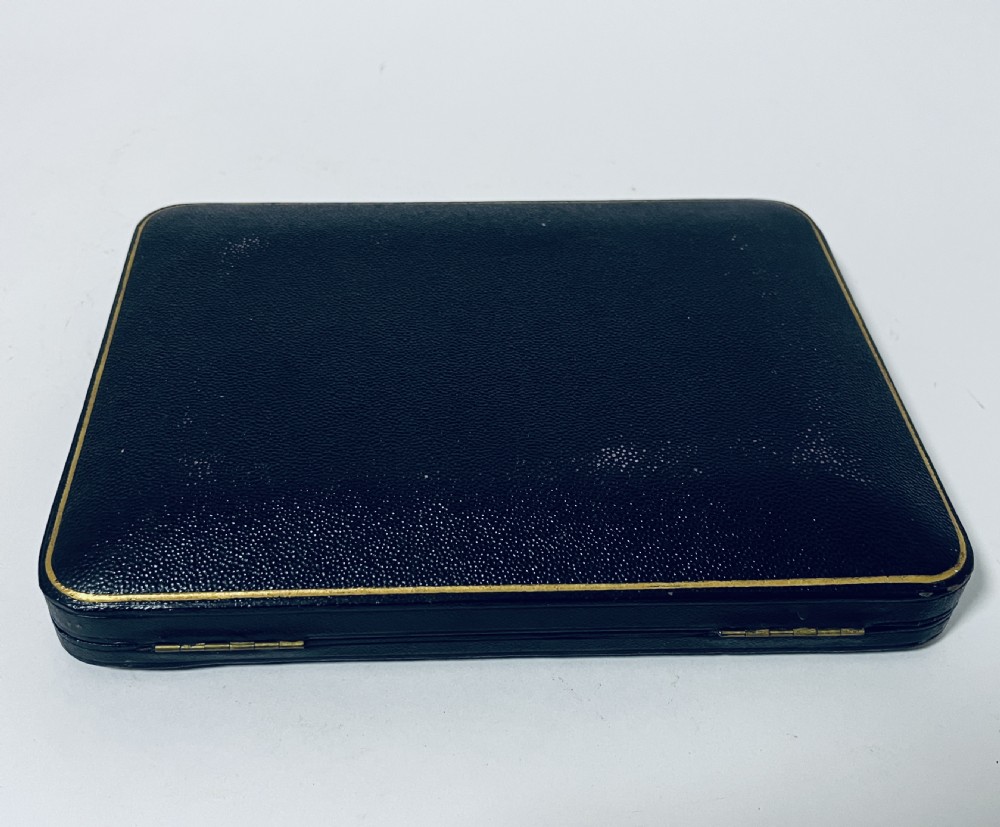 A cased set of six silver teaspoons and matching sugar tongs arranged in a blue velvet lined presentation box with cream satin lid. View IX