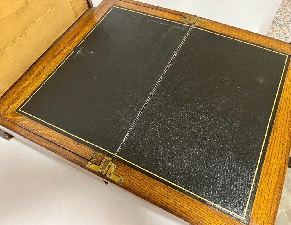 A rectangular Victorian dark oak stationery cabinet featuring a hinged drop-front, brass keyhole escutcheon, and an engraved metal plaque mounted on the top surface. View IV