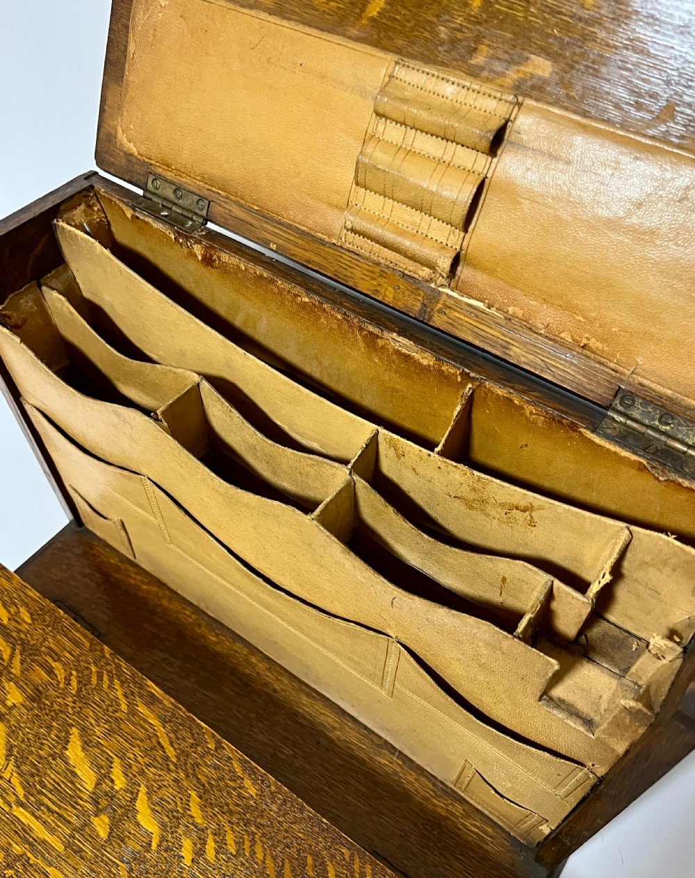 A rectangular Victorian dark oak stationery cabinet featuring a hinged drop-front, brass keyhole escutcheon, and an engraved metal plaque mounted on the top surface. View V