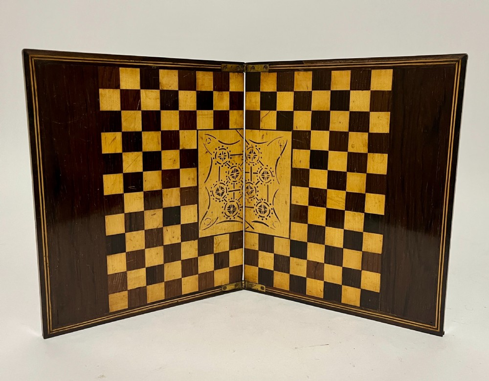 A two-panel antique mahogany solitaire games board featuring indented circular playing tracks alongside a collection of dark glass marbles. View XI
