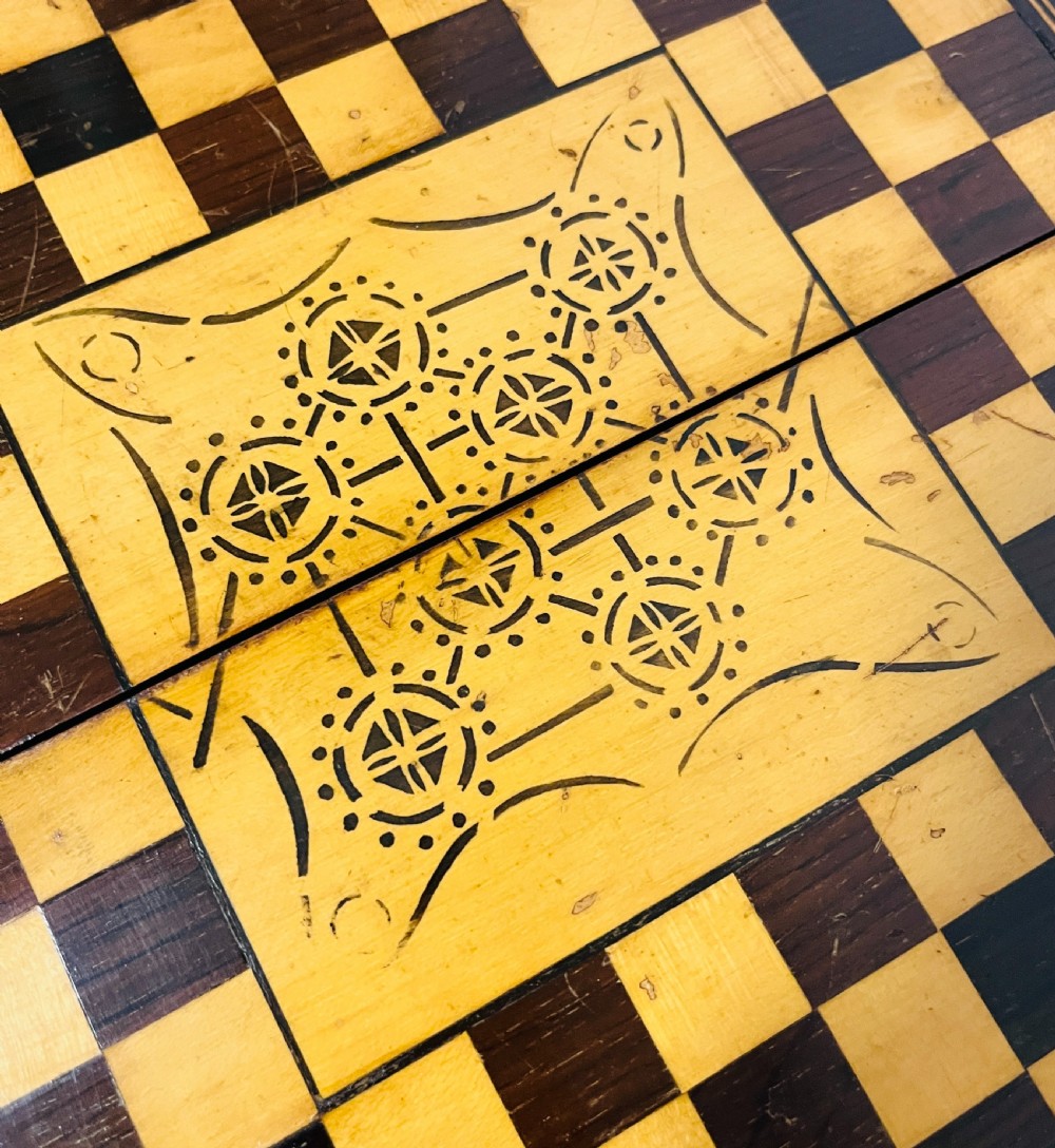 A two-panel antique mahogany solitaire games board featuring indented circular playing tracks alongside a collection of dark glass marbles. View XIII