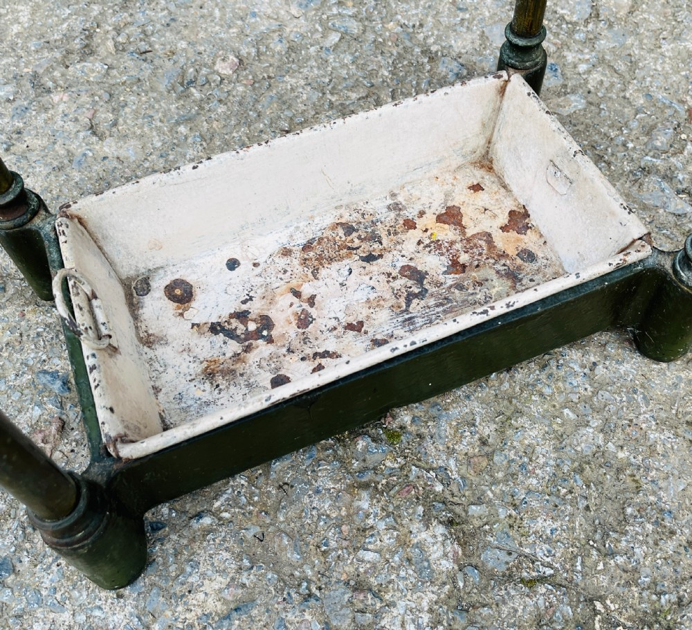 A Victorian brass stick stand featuring four upright posts with turned finials, a six-division top frame, and a painted metal drip tray at the base. View VII
