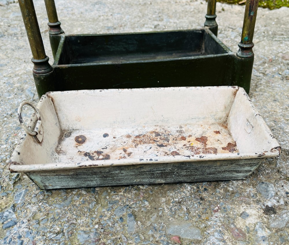 A Victorian brass stick stand featuring four upright posts with turned finials, a six-division top frame, and a painted metal drip tray at the base. View VIII