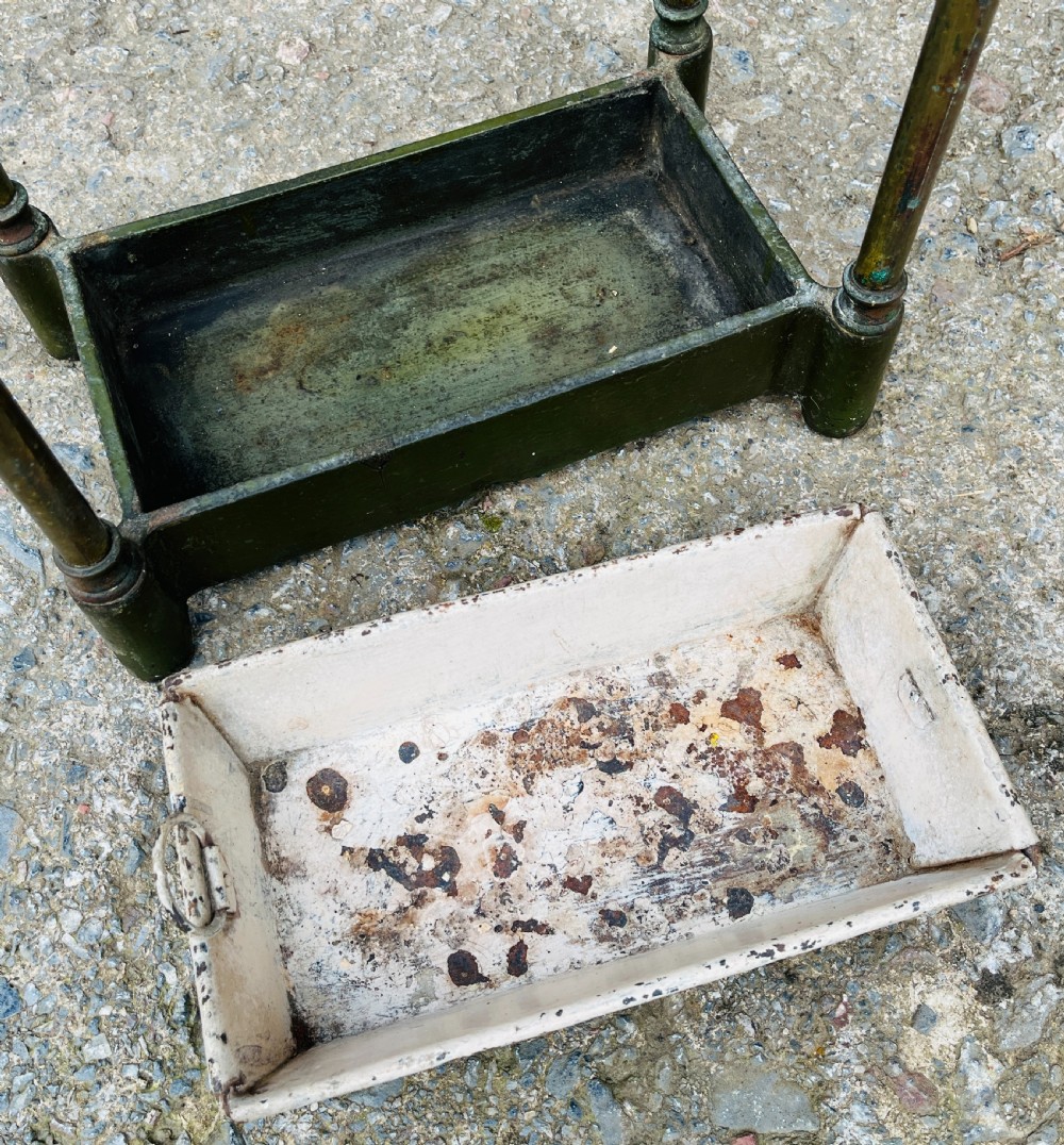 A Victorian brass stick stand featuring four upright posts with turned finials, a six-division top frame, and a painted metal drip tray at the base. View XI