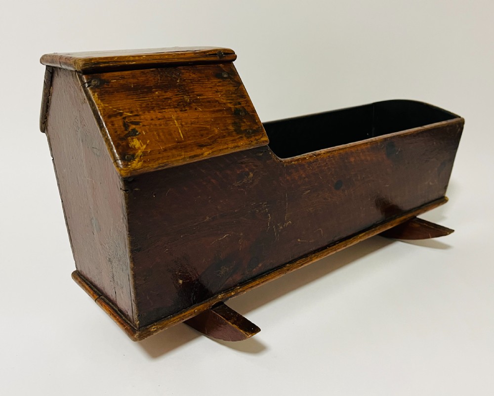 A dark stained pine miniature doll cradle featuring a hooded canopy and curved rockers. View IV