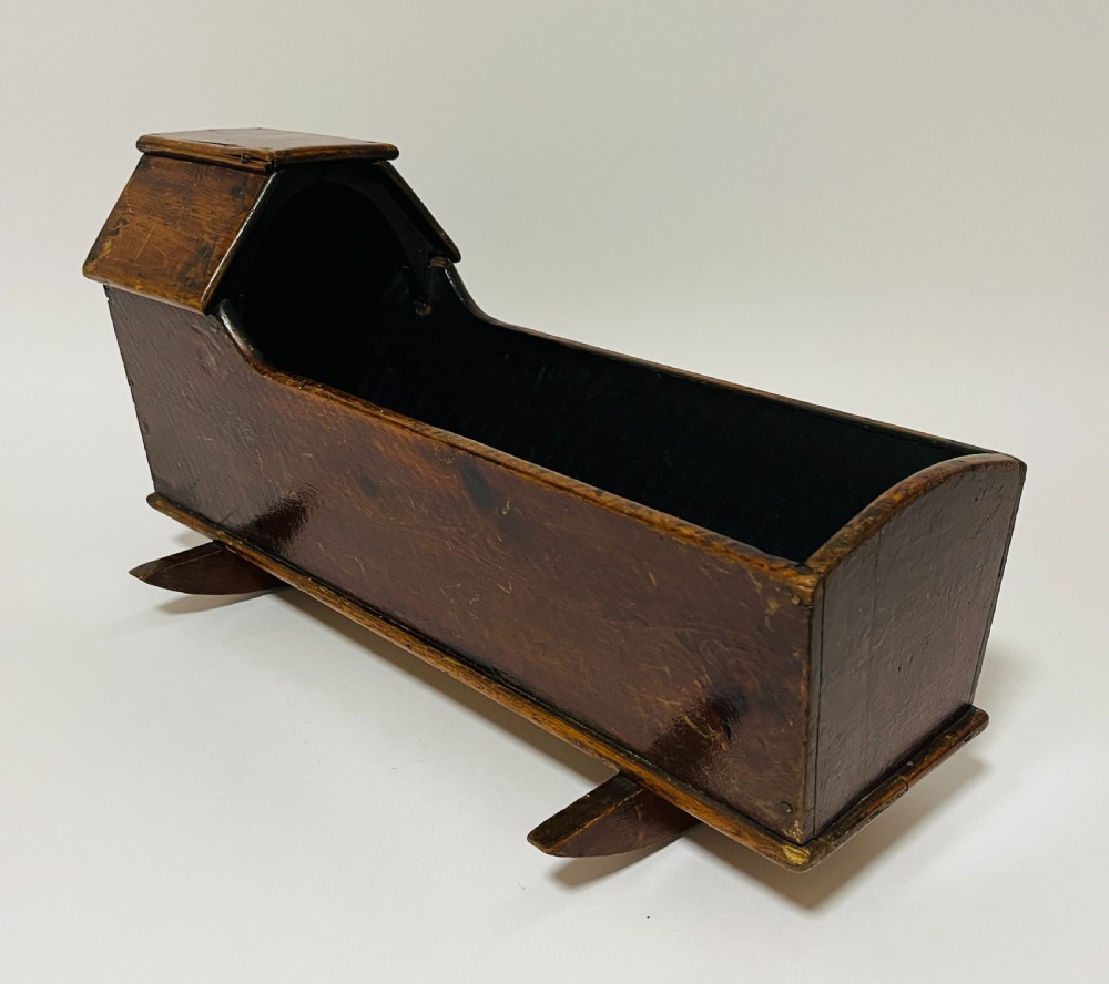 A dark stained pine miniature doll cradle featuring a hooded canopy and curved rockers. View VI