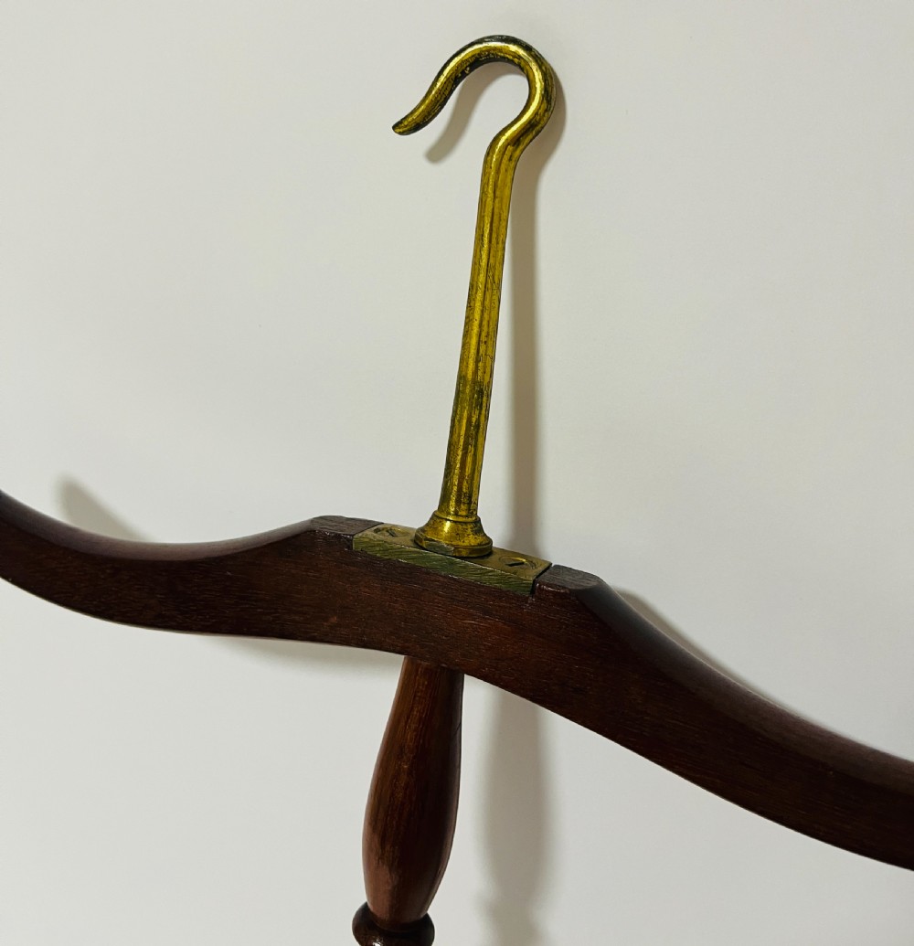 An antique dark mahogany gown and wig hanger featuring a contoured wooden shoulder bar, a turned central spindle, and a brass hook. View III