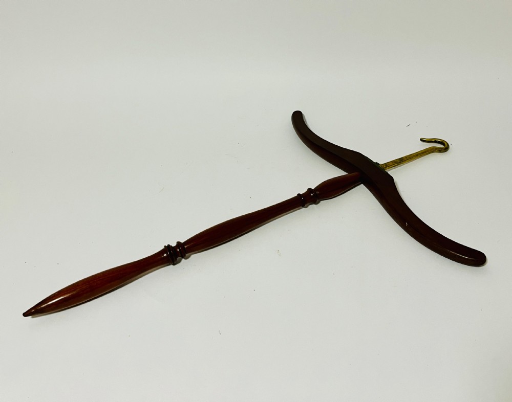An antique dark mahogany gown and wig hanger featuring a contoured wooden shoulder bar, a turned central spindle, and a brass hook. View IV