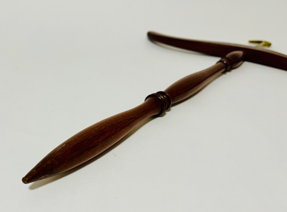 An antique dark mahogany gown and wig hanger featuring a contoured wooden shoulder bar, a turned central spindle, and a brass hook. View VI
