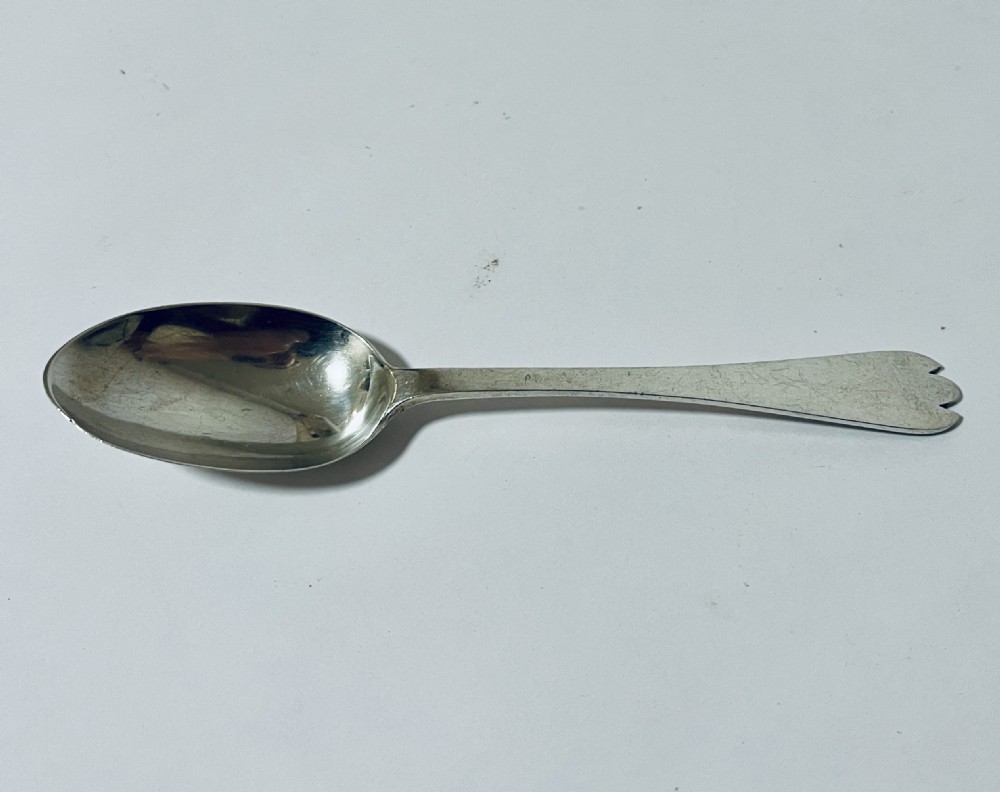An antique silver trefid spoon featuring a shallow oval bowl and a flat stem terminating in a distinctive notched three-pointed shape.