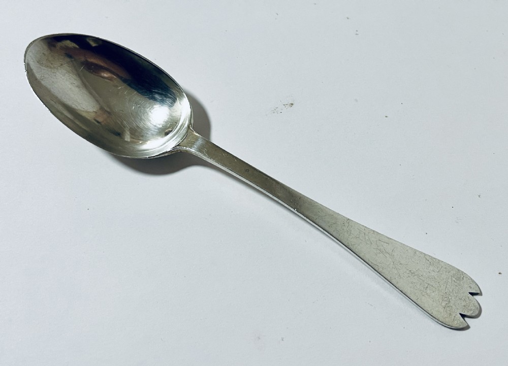 An antique silver trefid spoon featuring a shallow oval bowl and a flat stem terminating in a distinctive notched three-pointed shape. View III