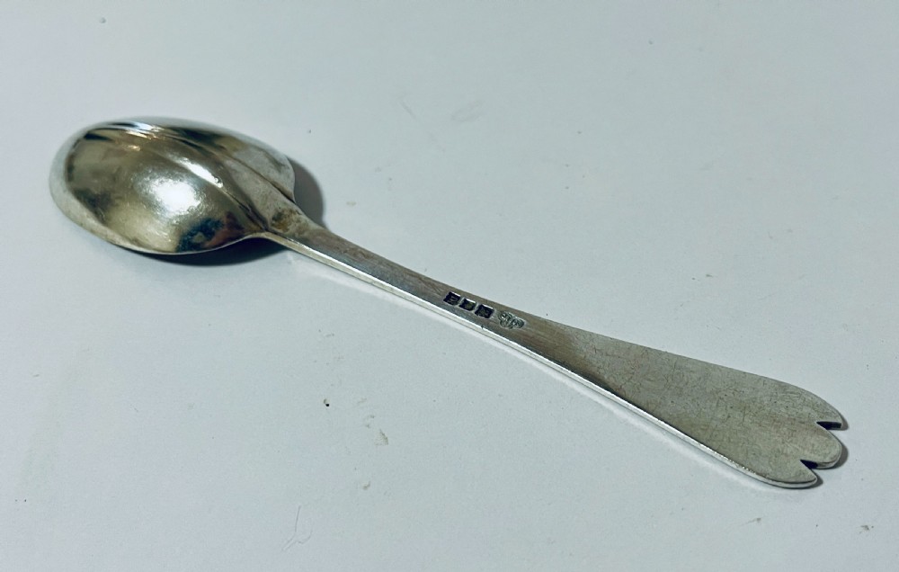An antique silver trefid spoon featuring a shallow oval bowl and a flat stem terminating in a distinctive notched three-pointed shape. View VIII