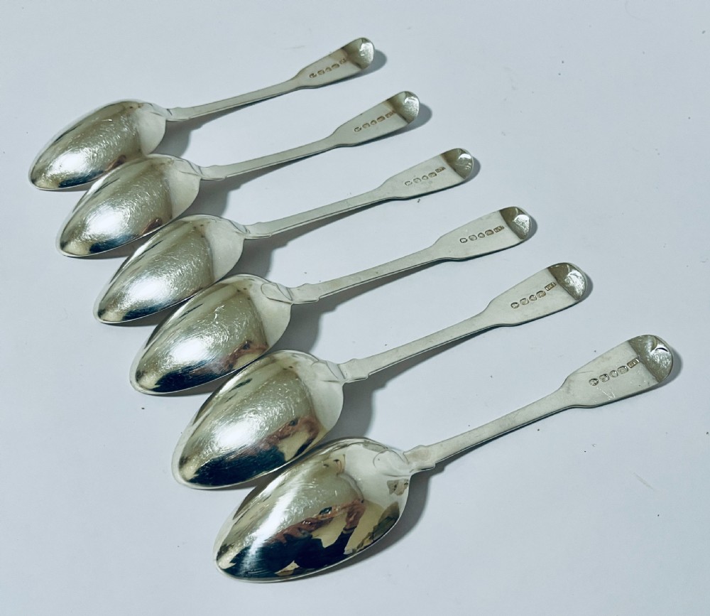 A set of six Georgian sterling silver tablespoons with oval bowls and engraved initial terminals laid out diagonally. View VII