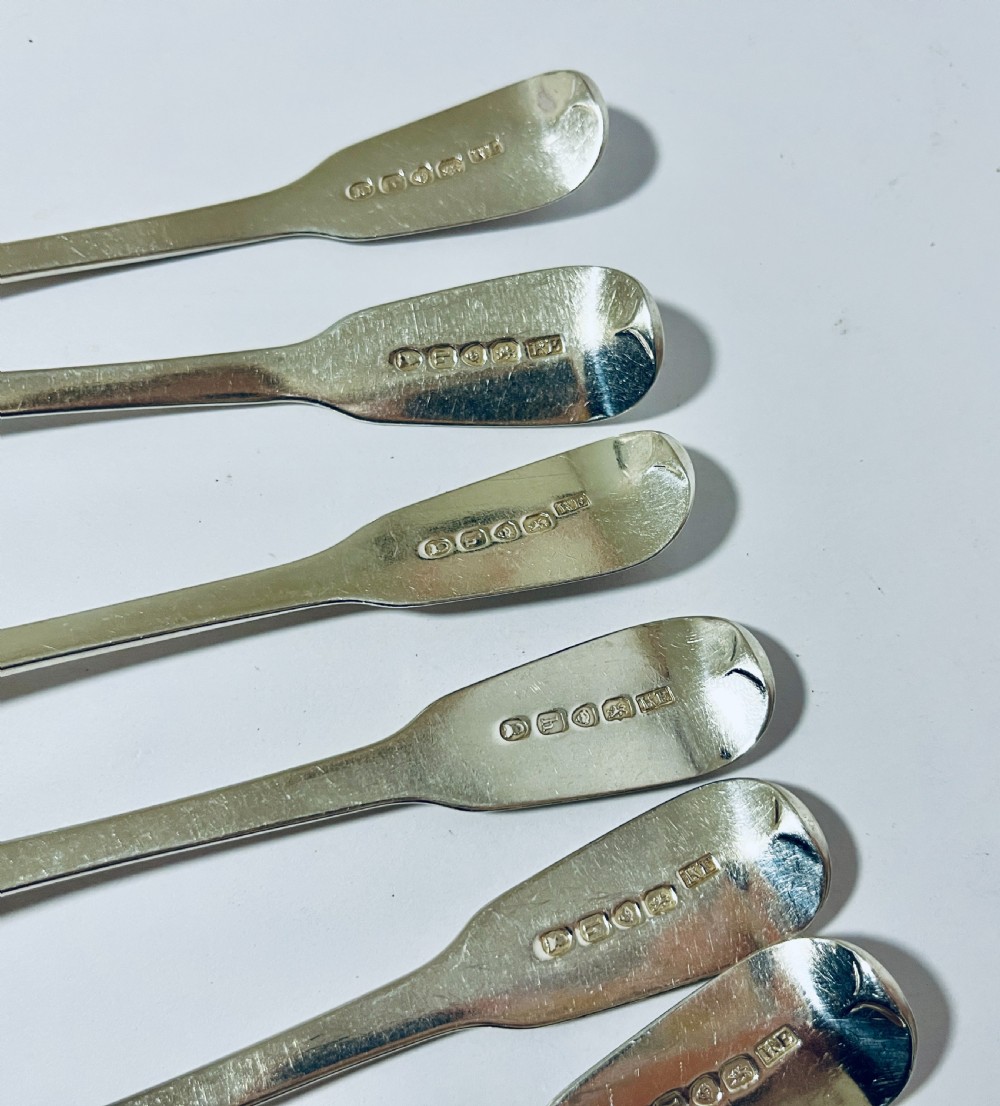 A set of six Georgian sterling silver tablespoons with oval bowls and engraved initial terminals laid out diagonally. View VIII