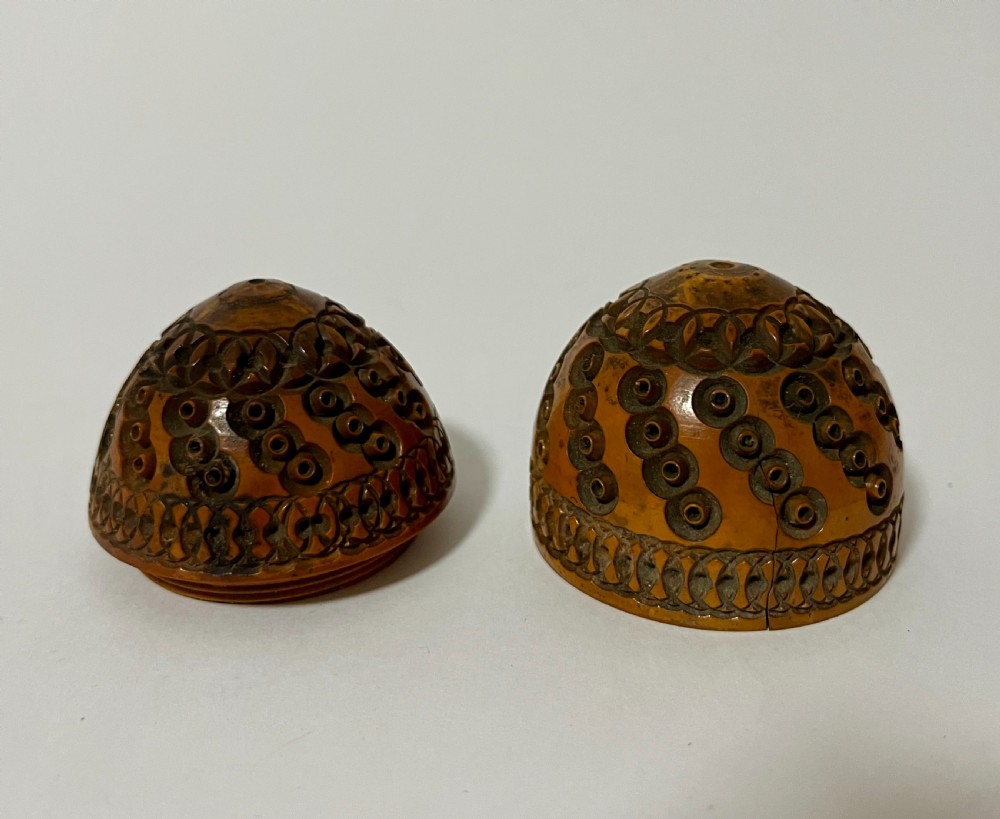 An egg-shaped Victorian pomander carved from warm brown coquilla nut with geometric circular pierced patterns. View VI