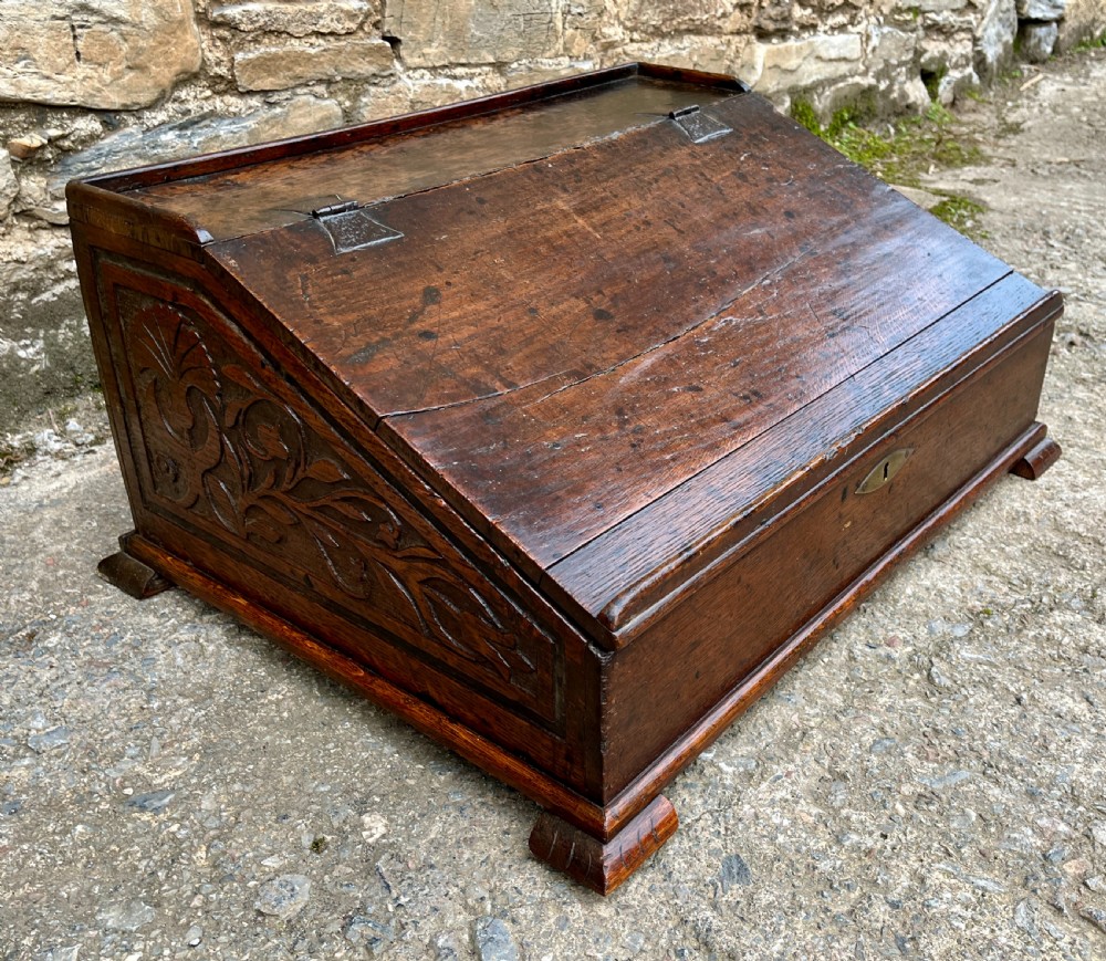 A 17th-century dark oak slant-top desk box featuring iron butterfly hinges and a central brass keyhole escutcheon. View II