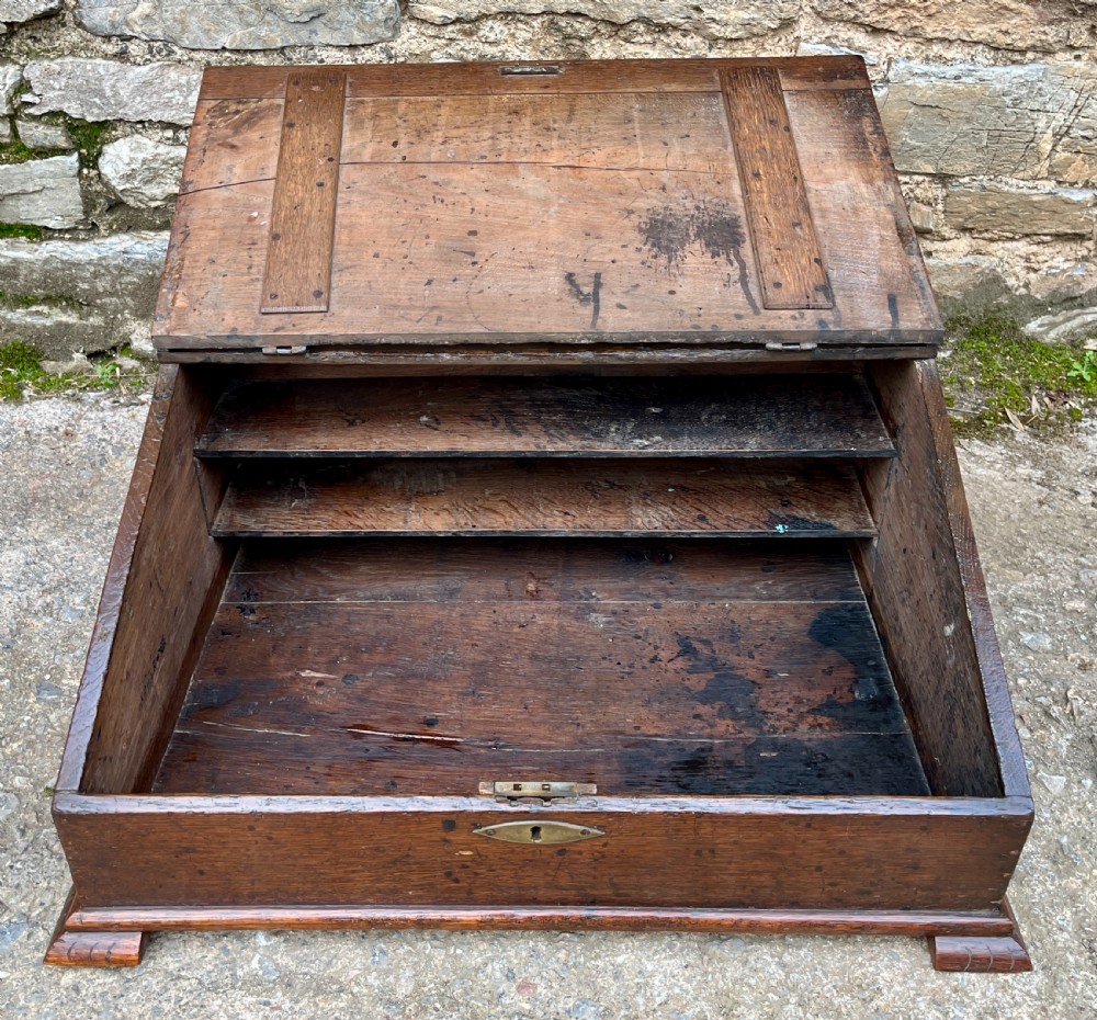 A 17th-century dark oak slant-top desk box featuring iron butterfly hinges and a central brass keyhole escutcheon. View IV