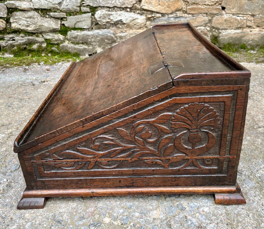 A 17th-century dark oak slant-top desk box featuring iron butterfly hinges and a central brass keyhole escutcheon. View V