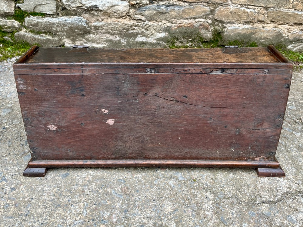 A 17th-century dark oak slant-top desk box featuring iron butterfly hinges and a central brass keyhole escutcheon. View VI