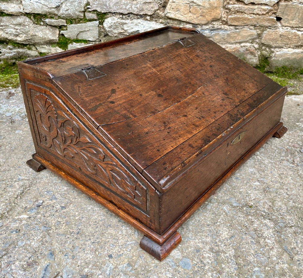 A 17th-century dark oak slant-top desk box featuring iron butterfly hinges and a central brass keyhole escutcheon. View XI