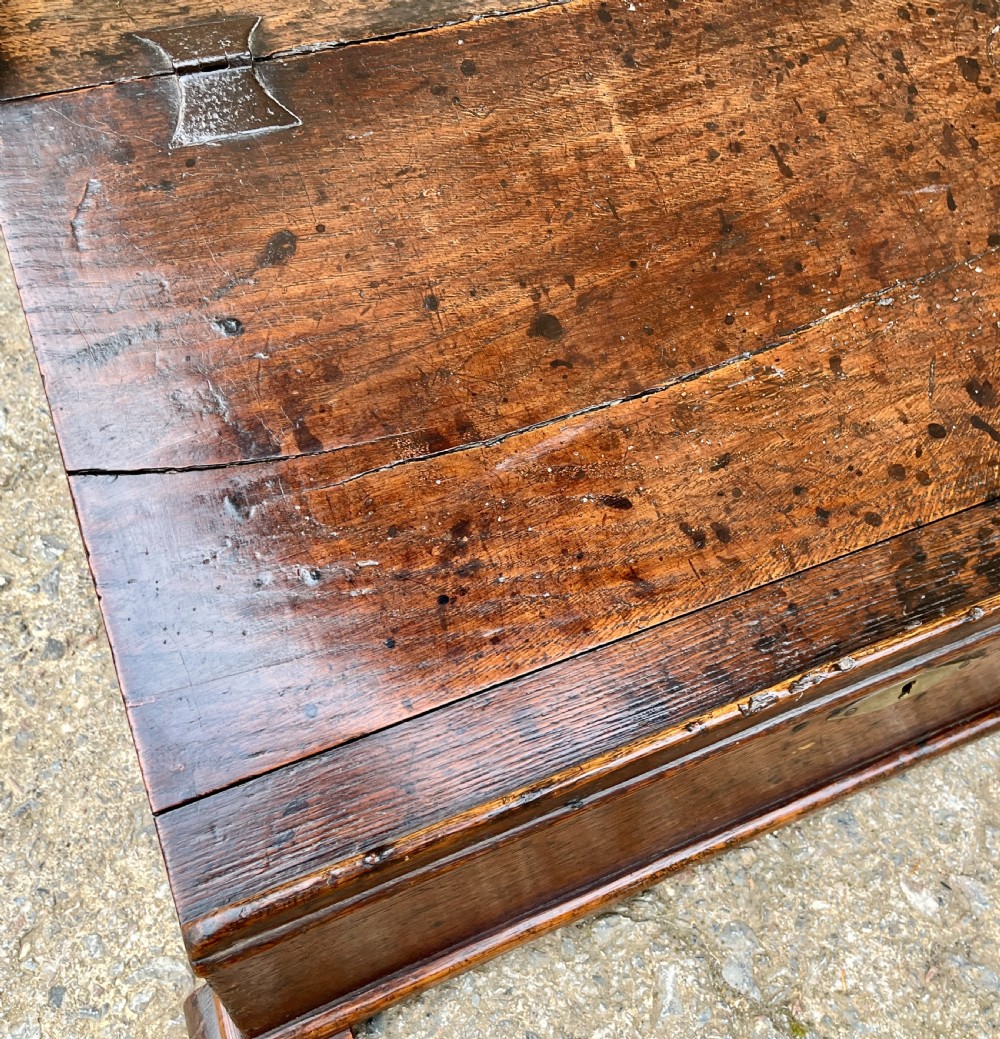 A 17th-century dark oak slant-top desk box featuring iron butterfly hinges and a central brass keyhole escutcheon. View XII