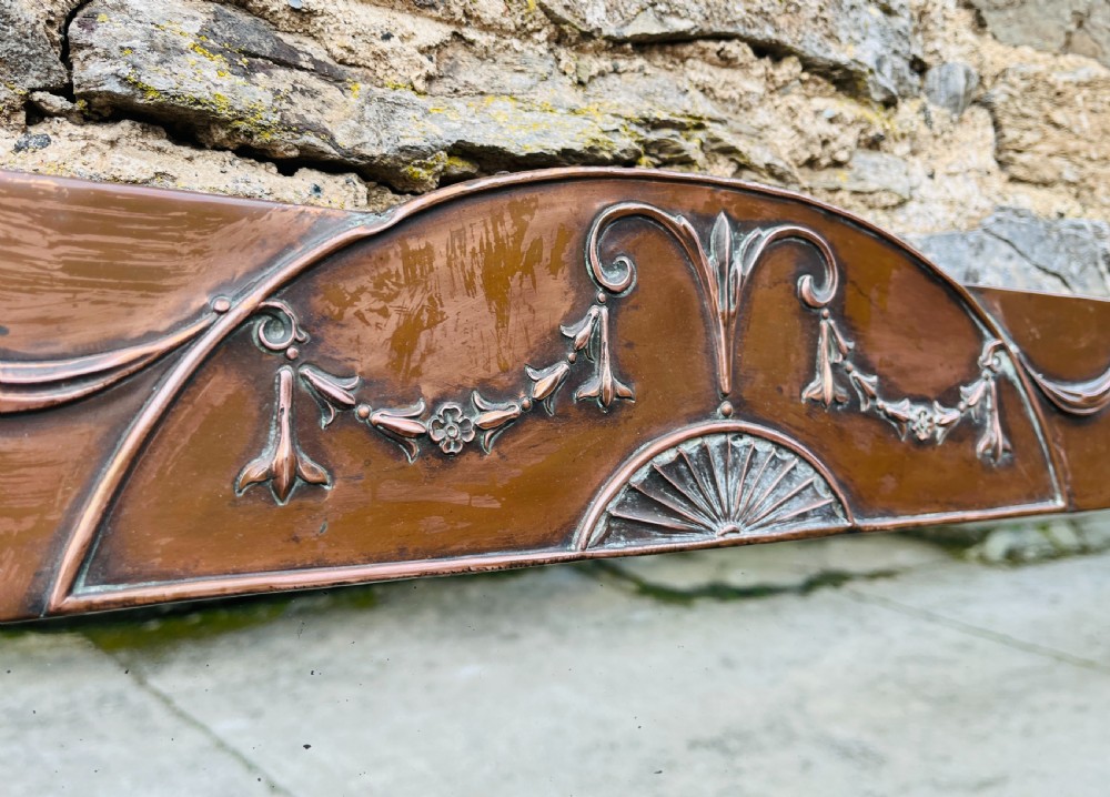 A rectangular Arts and Crafts wall mirror with an embossed copper frame featuring classical festoon motifs, an arched crest, and small green oval ceramic plaques. View IV