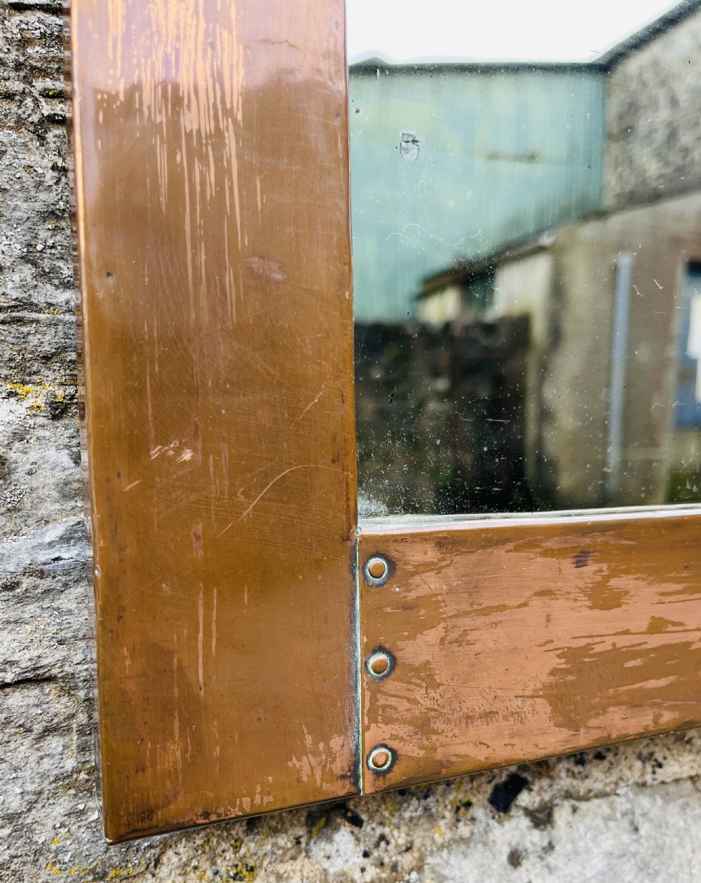 A rectangular Arts and Crafts wall mirror with an embossed copper frame featuring classical festoon motifs, an arched crest, and small green oval ceramic plaques. View VIII