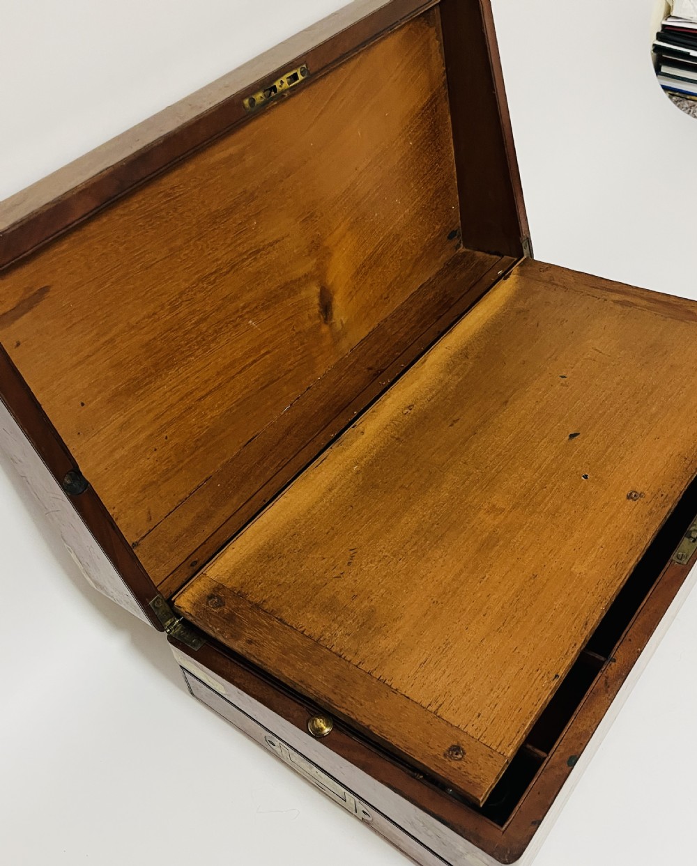 A rectangular mahogany wooden writing slope featuring protective brass corner brackets, brass straps, a central brass plaque, and a brass keyhole escutcheon. View IV