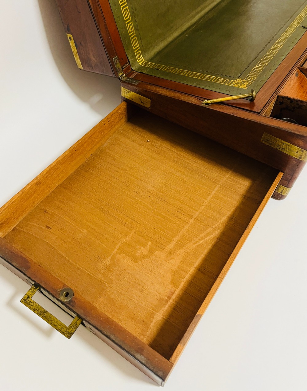 A rectangular mahogany wooden writing slope featuring protective brass corner brackets, brass straps, a central brass plaque, and a brass keyhole escutcheon. View VI