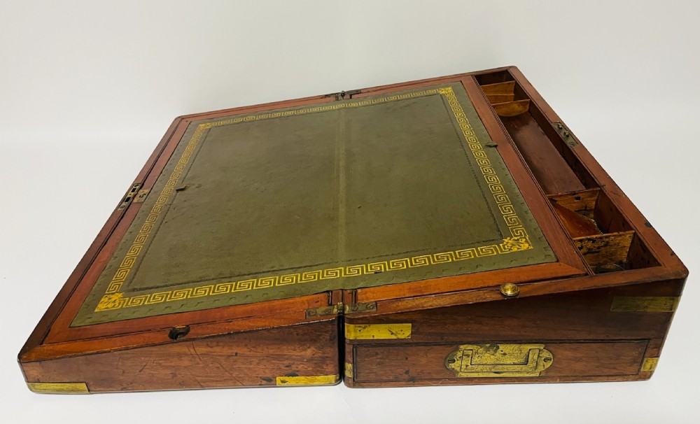 A rectangular mahogany wooden writing slope featuring protective brass corner brackets, brass straps, a central brass plaque, and a brass keyhole escutcheon. View VII