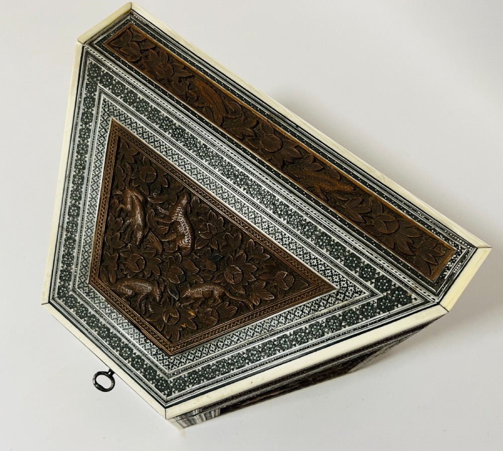 A slanted Anglo-Indian stationery box crafted from carved dark wood featuring intricate geometric bone inlay borders and relief floral panels. View X