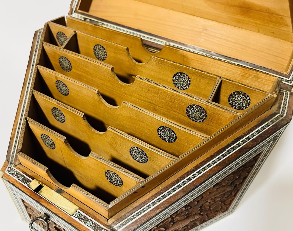 A slanted Anglo-Indian stationery box crafted from carved dark wood featuring intricate geometric bone inlay borders and relief floral panels. View XI