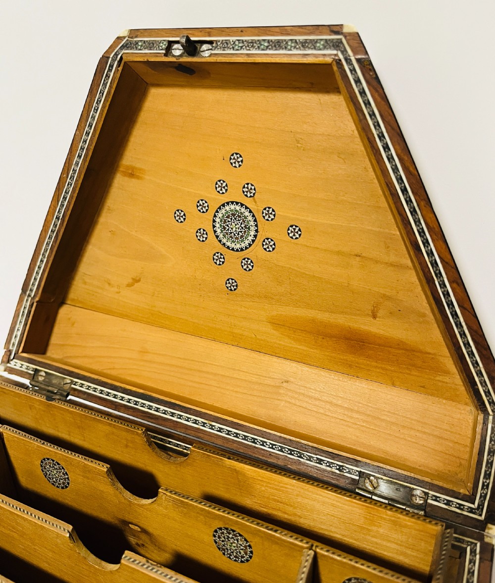 A slanted Anglo-Indian stationery box crafted from carved dark wood featuring intricate geometric bone inlay borders and relief floral panels. View XII