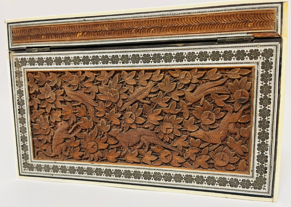 A slanted Anglo-Indian stationery box crafted from carved dark wood featuring intricate geometric bone inlay borders and relief floral panels. View XIV