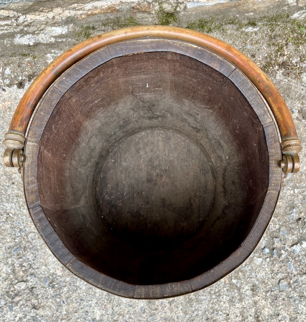 An antique coopered oak barrel featuring brass binding straps, a curved brass overhead handle, and an engraved brass presentation plaque on the front. View IV