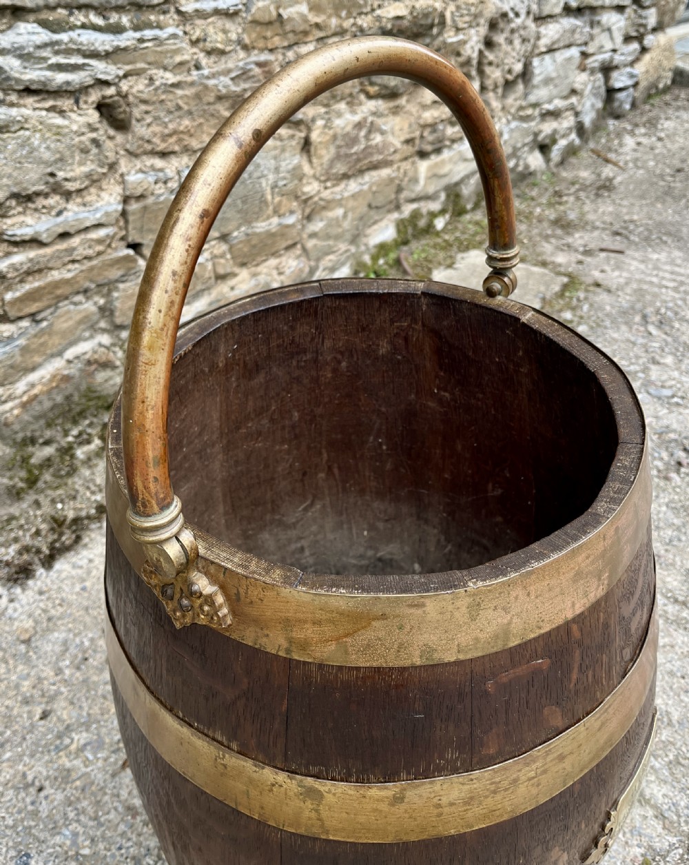 An antique coopered oak barrel featuring brass binding straps, a curved brass overhead handle, and an engraved brass presentation plaque on the front. View XII