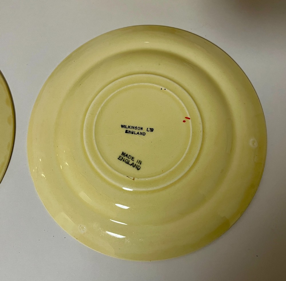 A pair of cream glazed earthenware soup coupes with twin handles and matching saucers decorated with ochre yellow, brown, and orange horizontal bands. View VII