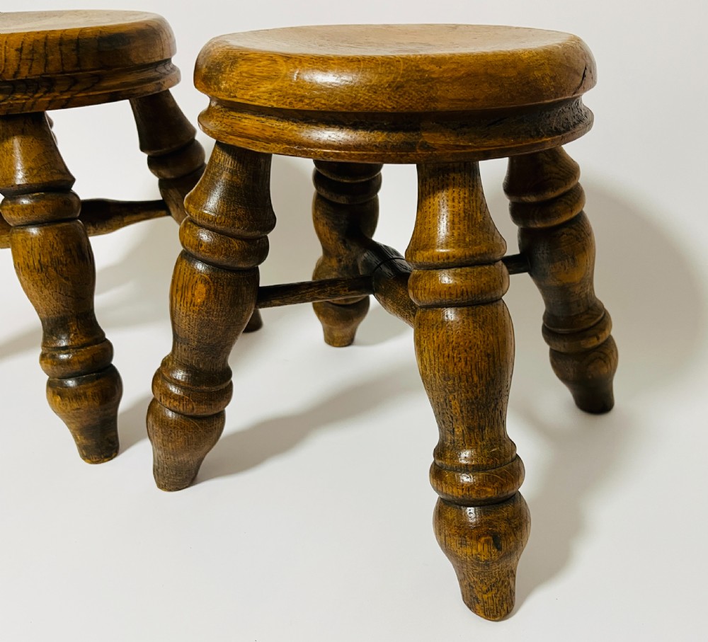 A pair of small antique oak stools with circular dished tops, turned baluster legs, and cross stretchers. View IV