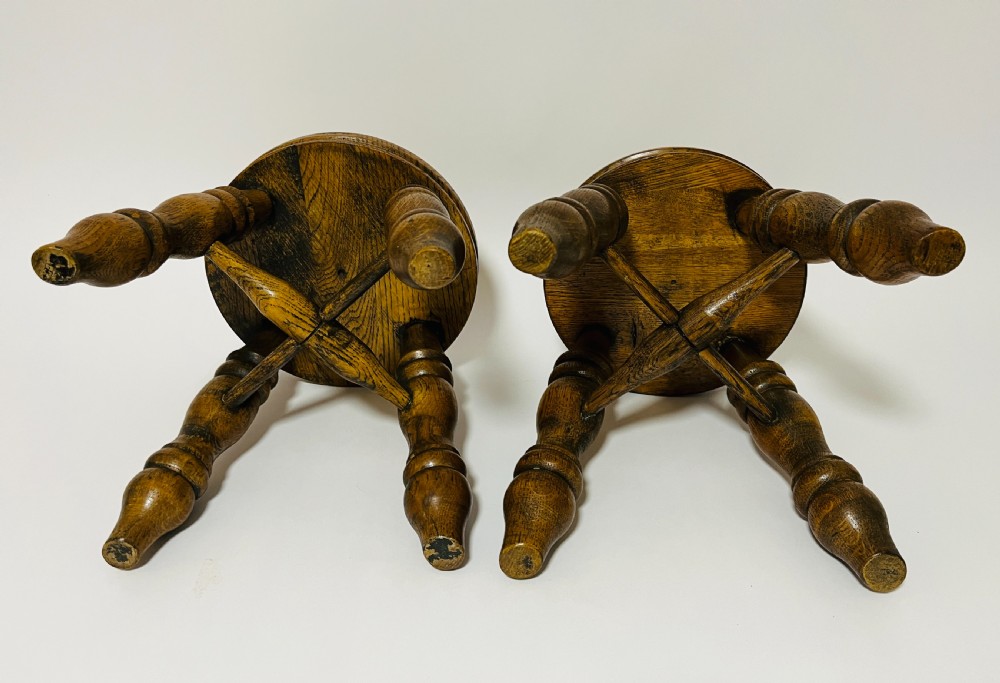 A pair of small antique oak stools with circular dished tops, turned baluster legs, and cross stretchers. View VI