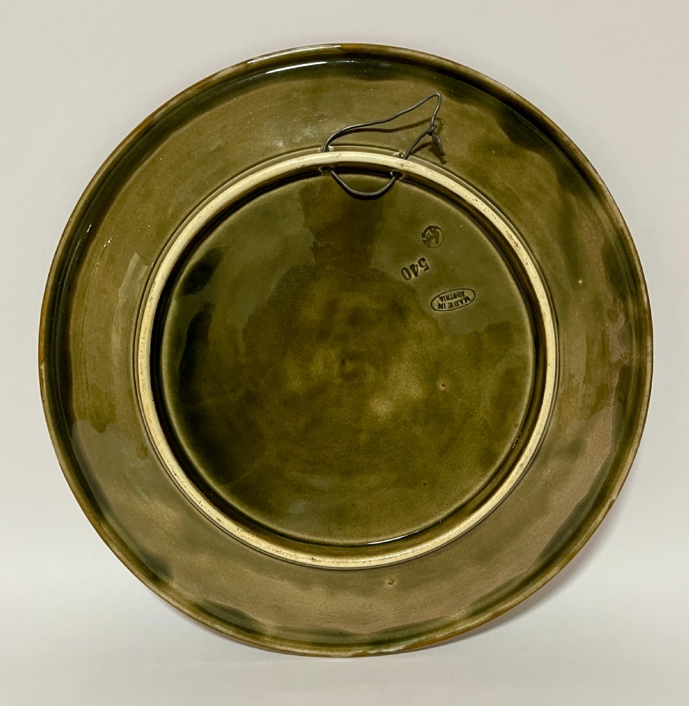 A circular Victorian majolica charger featuring relief figures of children and scrollwork in cobalt blue, ochre, and ivory glazes. View IV