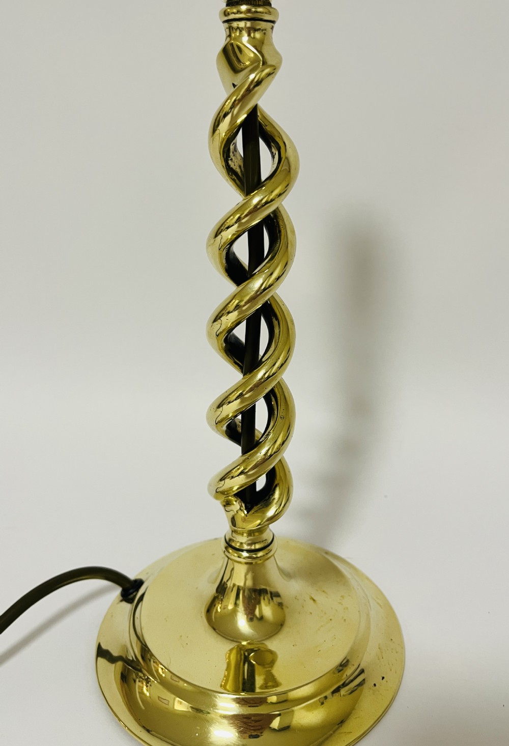 A polished brass table lamp featuring an open barley twist column set upon a round stepped base. View IV