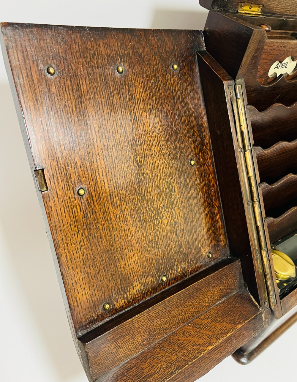 An open Victorian dark oak stationery cabinet featuring fitted letter slots, an integrated perpetual calendar, twin inkwells, and hinged side doors. View VII