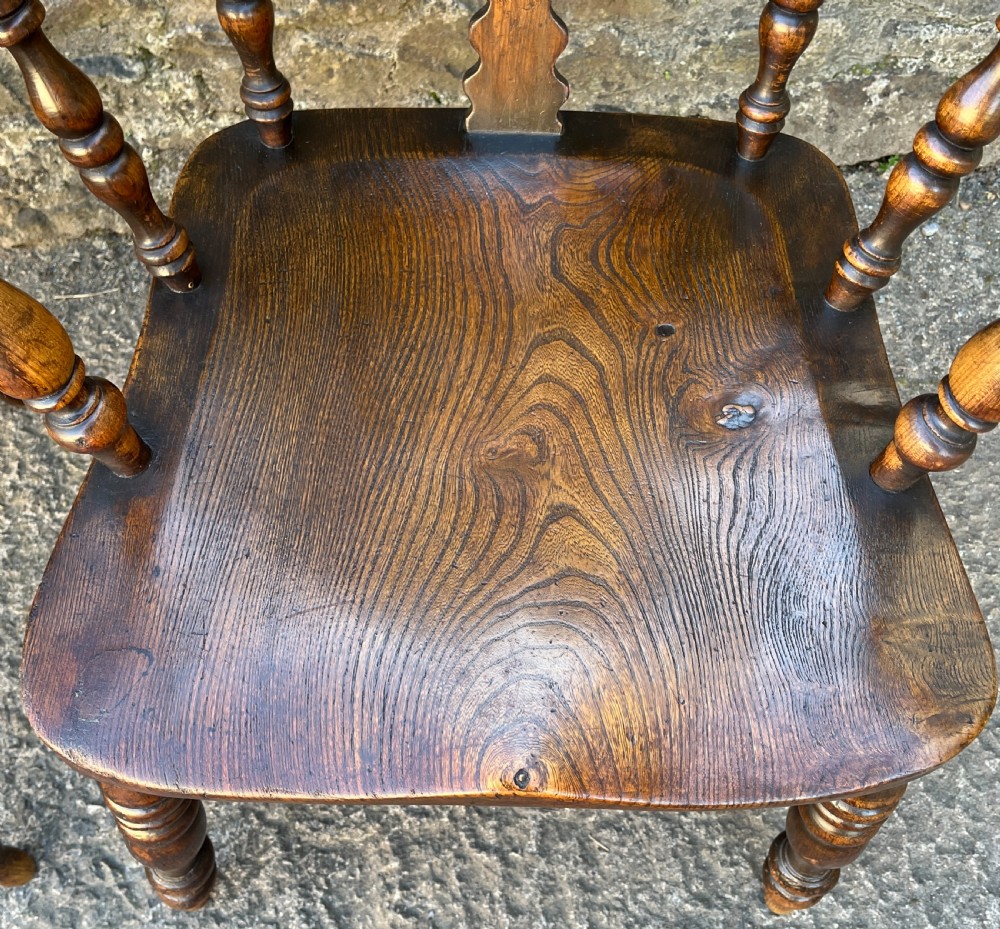 A pair of antique wooden Windsor armchairs featuring curved hoop backs, pierced central splats, broad armrests, and turned legs. View IV
