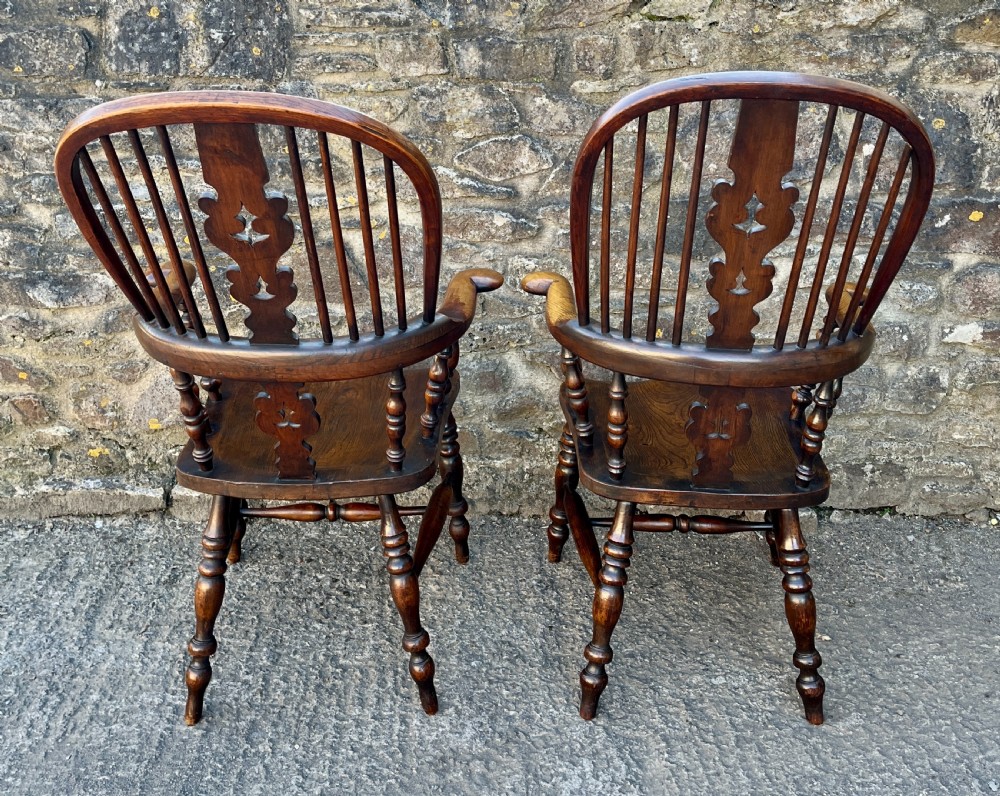 A pair of antique wooden Windsor armchairs featuring curved hoop backs, pierced central splats, broad armrests, and turned legs. View VII