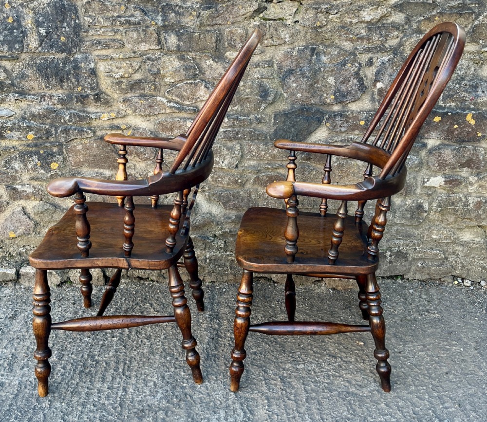 A pair of antique wooden Windsor armchairs featuring curved hoop backs, pierced central splats, broad armrests, and turned legs. View VIII