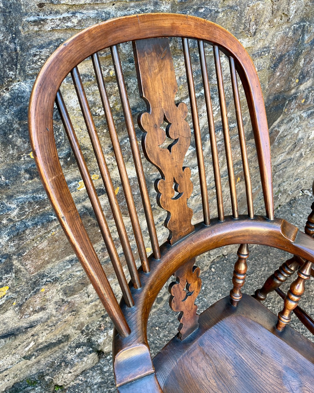 A pair of antique wooden Windsor armchairs featuring curved hoop backs, pierced central splats, broad armrests, and turned legs. View XI