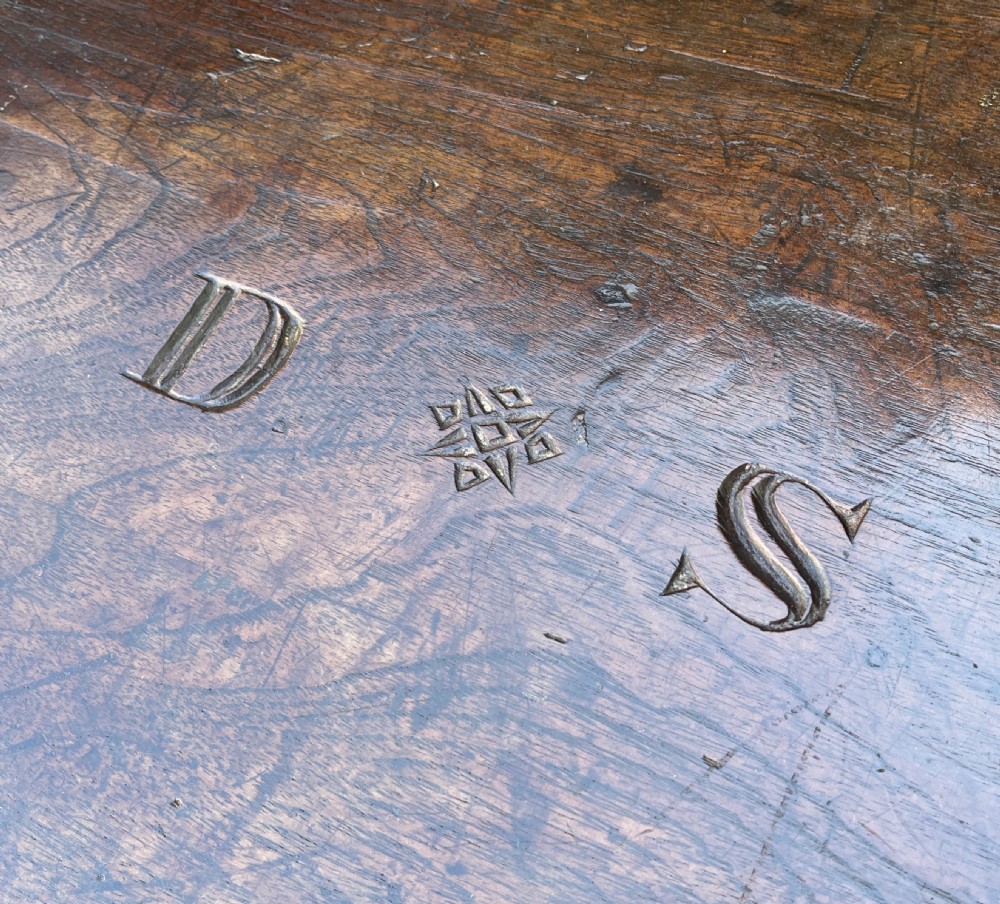 A rectangular dark teak blanket chest featuring carved initials on the hinged lid, exposed dovetail joints, and a keyhole escutcheon on the front. View IV